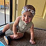 baby, child, headband, romper, carpet, door, mesh_screen, indoor, crawling, shoes, happy, curious, person, infant, floor, yellow, window, sunlight, smile, cute