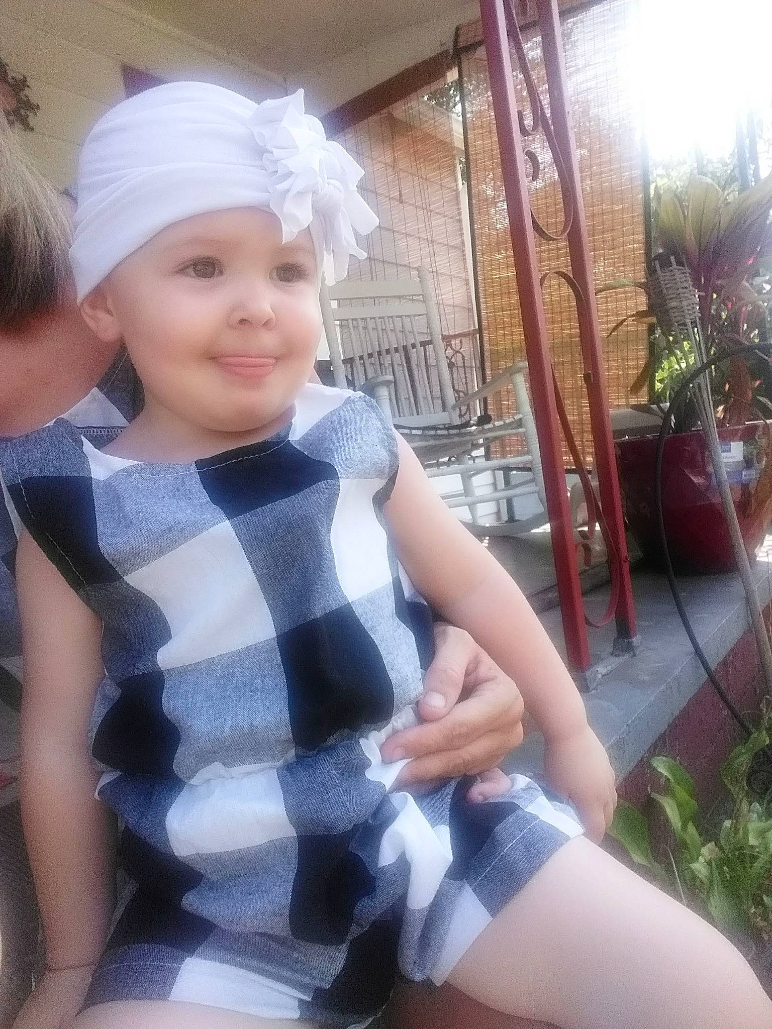 Harper is registered to the contest to win money with this photo: blond, cap, child, cool, costume_hat, event, fashion_accessory, happy, hat, headwear, houseplant, human_leg, joy, knee, pattern, person, plaid, plant, skin, sleeve