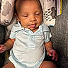Kamari is registered to the contest to win money with this photo: baby, child, infant, onesie, sleeping, tongue_out, seat, cushion, patterned_fabric, indoor, cute, resting, small_hands, small_feet, person, young_child, portrait, cozy, relaxed, newborn