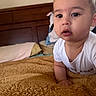 baby, infant, child, face, portrait, bedroom, blanket, pillow, wooden_headboard, white_clothing, curious_expression, indoors, crawling, soft_texture, closeup, young_child, skin, person, head, eyes