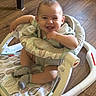 baby, smiling, winking, baby_walker, striped_clothing, socks, wooden_floor, child, happy, infant, seated, indoor, playful, cute, person, young_child, fabric, pattern, footwear, toy