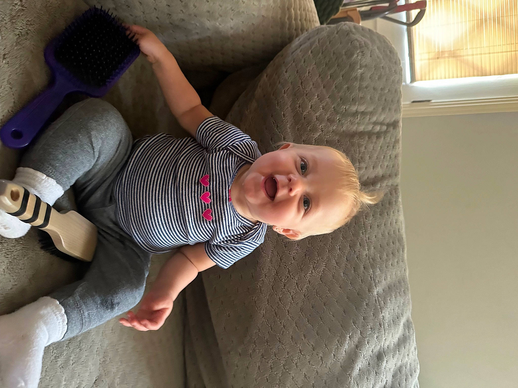 Athena is registered to the contest to win money with this photo: arm, baby, baby_toddler_clothing, comfort, couch, elbow, finger, flooring, hand, human_body, human_leg, joint, knee, leg, linens, person, skin, textile, thigh, toddler