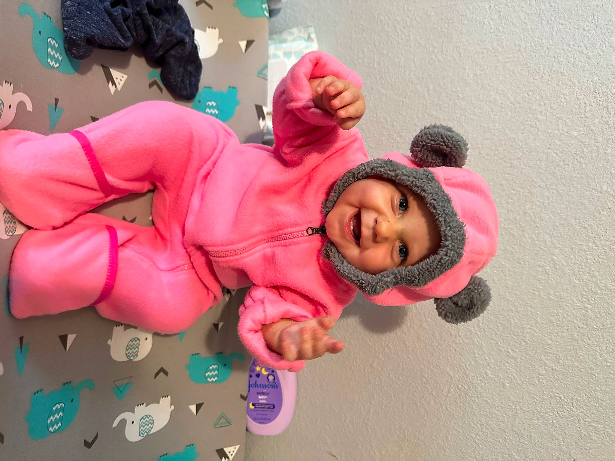 Athena is registered to the contest to win money with this photo: baby_toddler_clothing, carmine, cheek, child, comfort, flooring, fun, happy, head, headwear, joy, leisure, magenta, person, pink, play, room, sitting, skin, sleeve