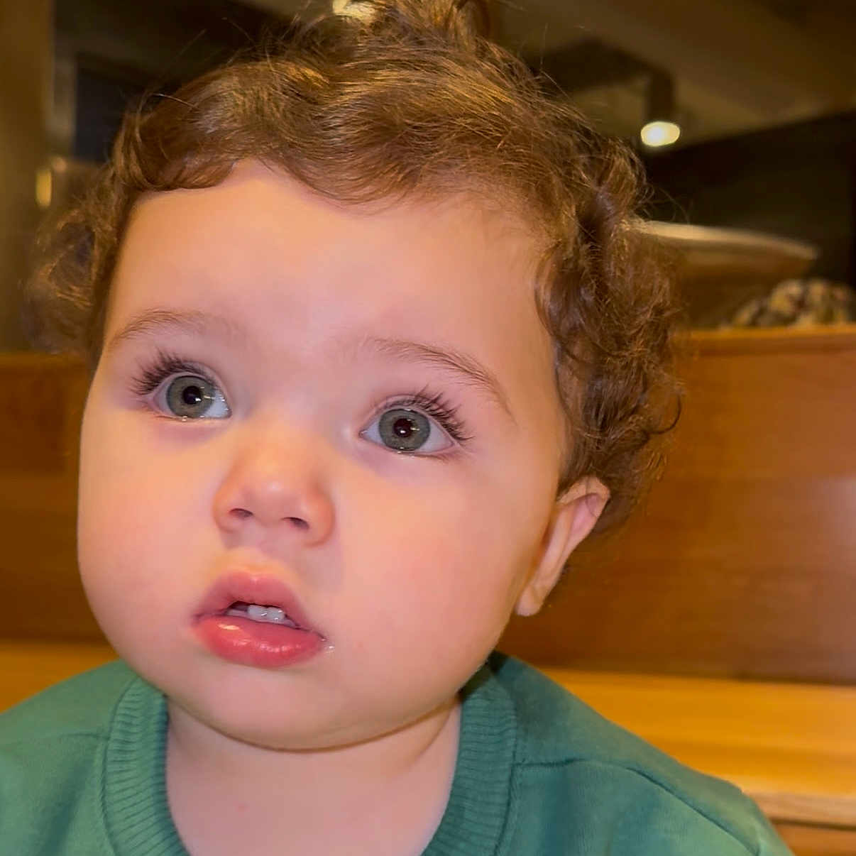 Jad joined the competition — help win amazing prizes! casual_clothing, child, close_up, curiosity, curly_hair, cute, expression, face, green_sweater, indoor, innocence, person, portrait, seat, soft_lighting, toddler, wide_eyes, wooden_furniture, young_child, young_face