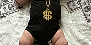Eden participe au concours pour gagner de l'argent avec cette photo : baby, infant, beanie, black_onesie, gold_necklace, dollar_sign, money, dollar_bills, blanket, lying_down, flexing, cute, chubby, arm_raised, expression, indoors, soft_texture, foot, hand, person