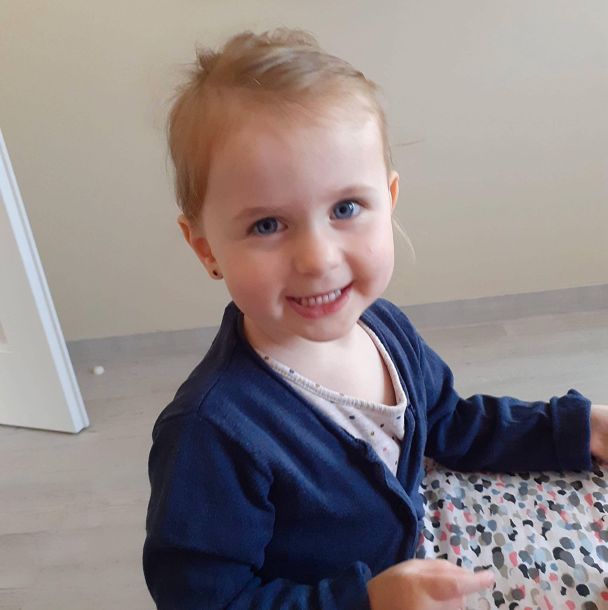 Lylou a rejoint le concours — aidez-le/la à gagner de superbes lots ! arm, blond, cheek, child, eye, face, facial_expression, finger, hair, hairstyle, head, joy, outerwear, person, photography, shoulder, sitting, skin, smile, standing