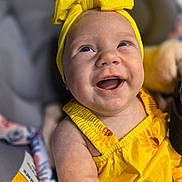 Averianna Rayne joined the competition — help win amazing prizes! baby, child, smiling, yellow_clothing, headband, sunflower_pattern, happy, cute, portrait, infant, skin, hand, face, person, indoors, closeup, expression, joy, holding, seat