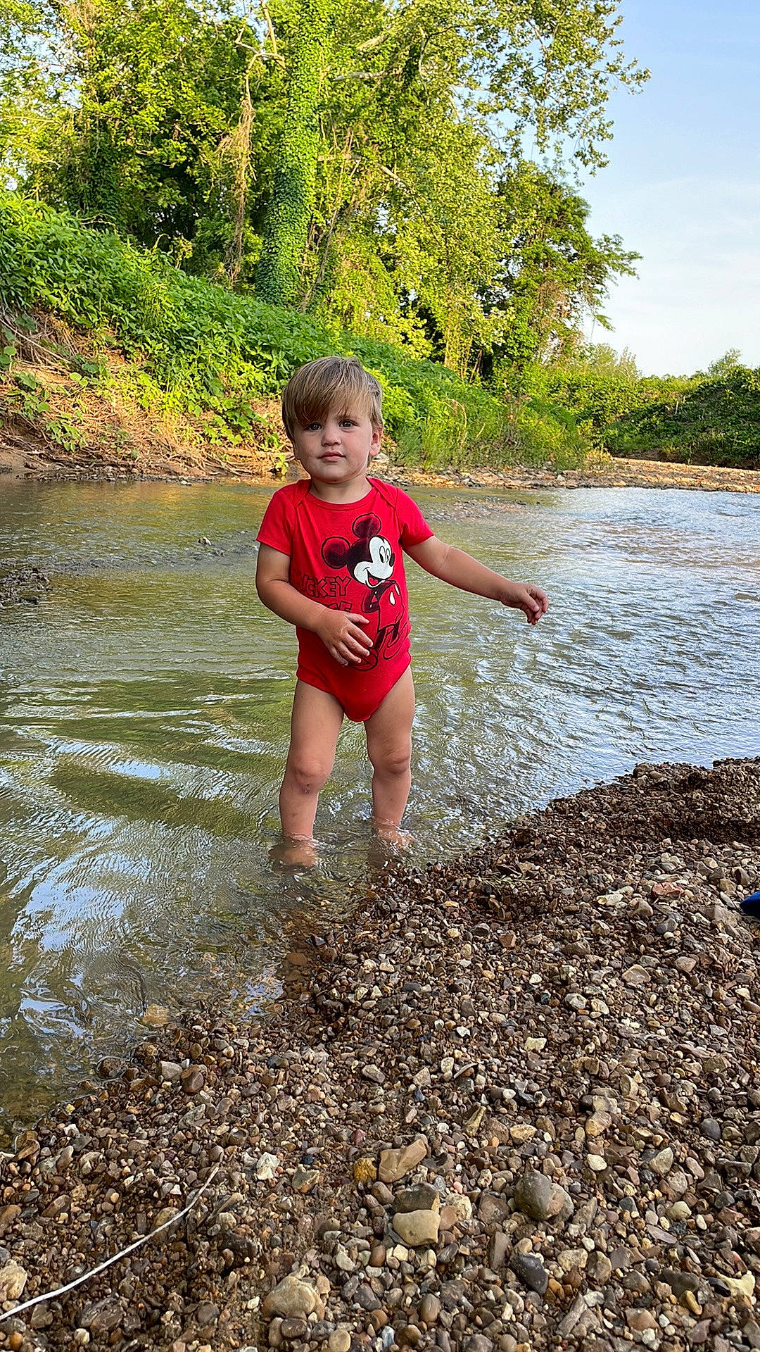 Karter is registered to the contest to win money with this photo: bank, beach, fun, grass, happy, lake, landscape, leisure, people_in_nature, person, puddle, recreation, rock, sky, soil, stream, t_shirt, toddler, tree, water