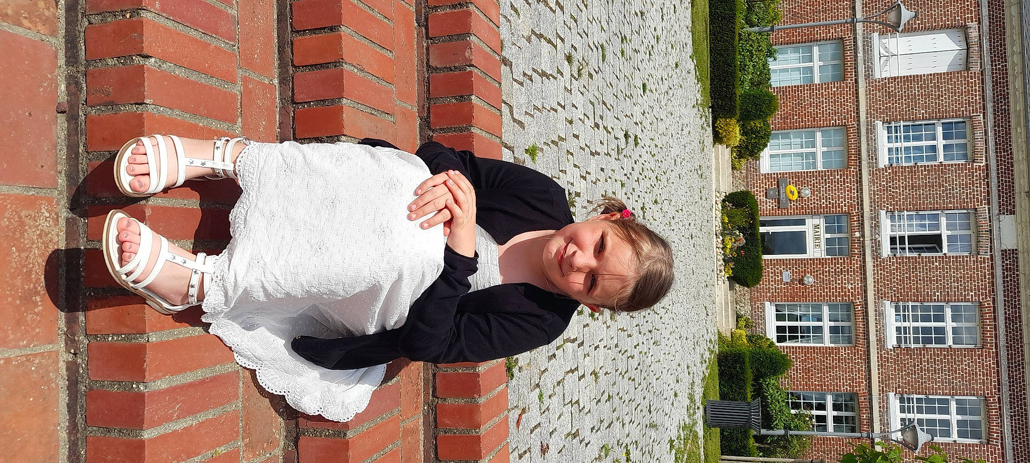 Clelia participe au concours pour gagner de l'argent avec cette photo : brick, brickwork, building, dress, eyewear, fun, gesture, grass, happy, human_leg, joy, leisure, person, plant, sitting, smile, thigh, tree, waist, wedding