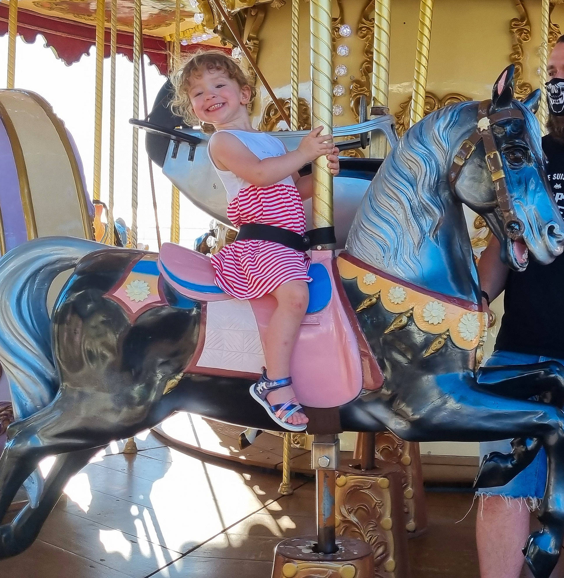 Emma participe au concours pour gagner de l'argent avec cette photo : amusement_park, amusement_ride, blue, bridle, carousel, electric_blue, event, fun, happy, horse, horse_tack, human_leg, joy, leisure, nonbuilding_structure, person, playground, recreation, smile, thigh