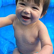 Leonardo is registered to the contest to win money with this photo: baby, child, smiling, water, pool, outdoor, summer, wet, skin, blue, diaper, cute, happy, playful, sitting, person, closeup, face, joy, infant