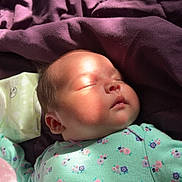 Rosalyn joined the competition — help win amazing prizes! baby, sleeping, infant, onesie, floral_pattern, blanket, purple_blanket, sunlight, peaceful, face, head, hand, baby_wipes, soft, cozy, resting, indoor, child, cute, portrait