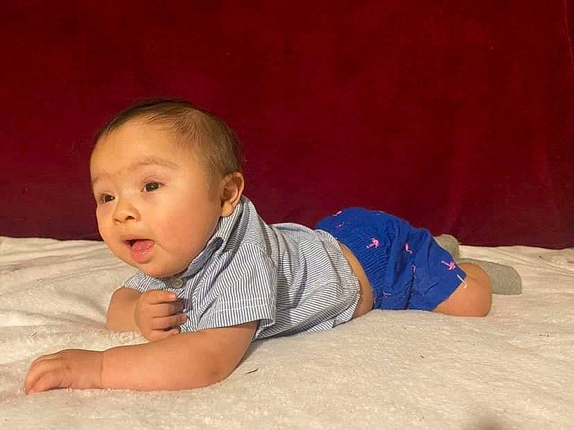 Valentin is registered to the contest to win money with this photo: arm, baby, baby_toddler_clothing, cheek, child, comfort, flash_photography, floor, flooring, fun, grass, happy, hardwood, nose, person, sitting, sleeve, t_shirt, toddler, tummy_time