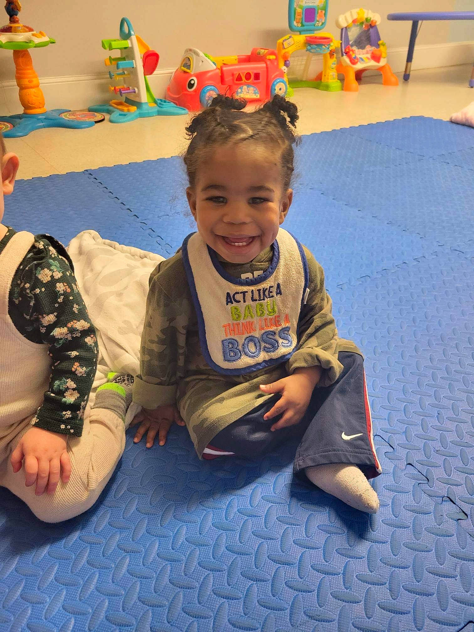 Legend is registered to the contest to win money with this photo: adaptation, art, baby, child, event, facial_expression, floor, flooring, fun, happy, human_body, joy, kindergarten, leisure, person, play, recreation, room, sitting, smile