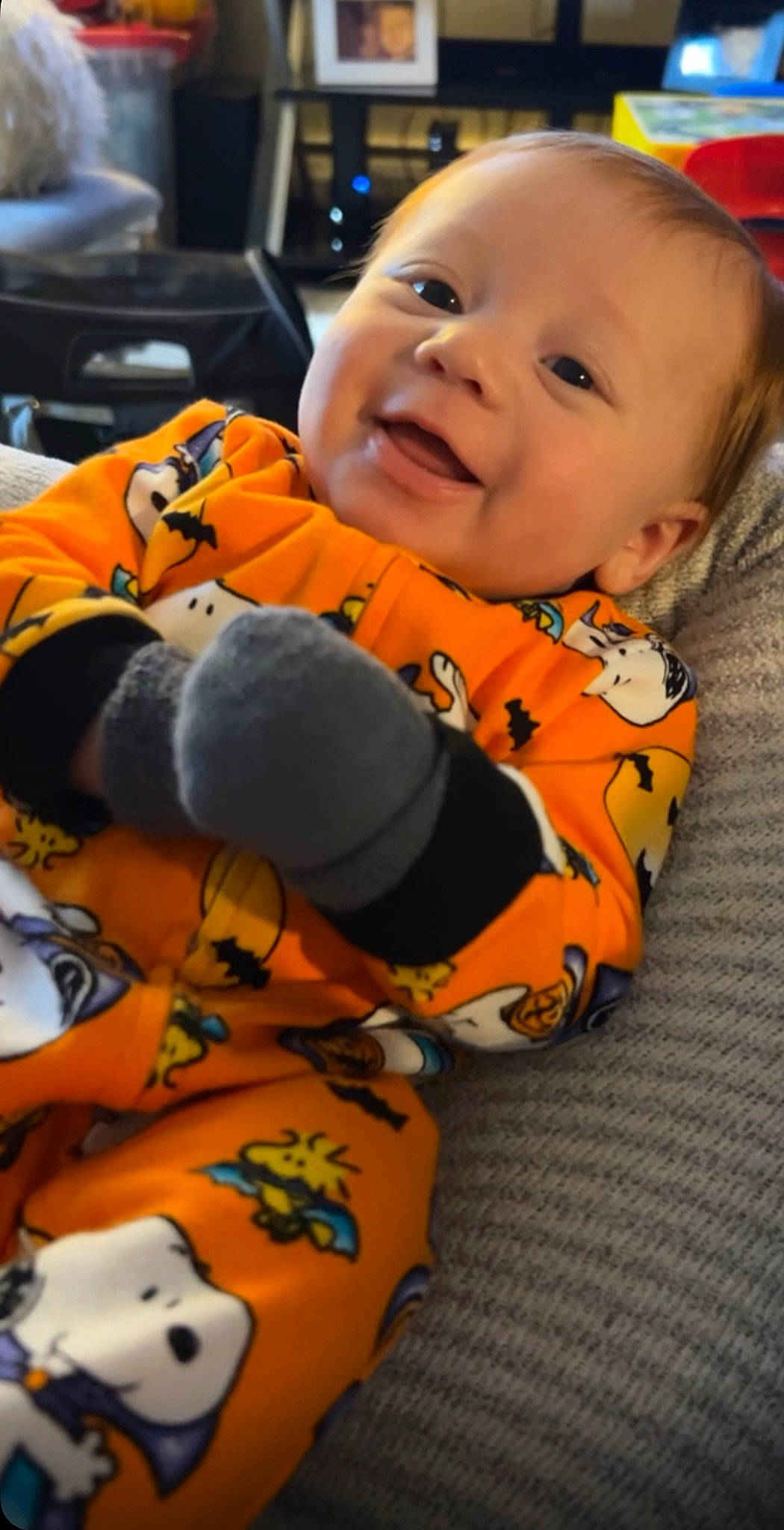 Jeremiah is registered to the contest to win money with this photo: baby, baby_toddler_clothing, cheek, child, comfort, eye, facial_expression, fun, happy, human_body, iris, mouth, nose, orange, person, skin, sleeve, smile, textile, toddler
