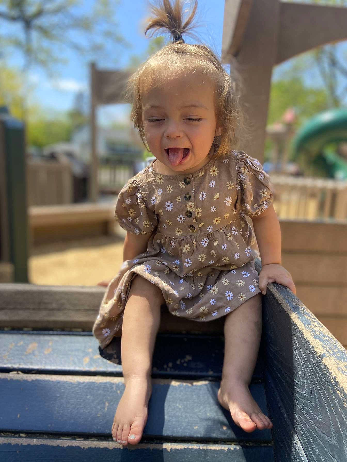 Kinzley is registered to the contest to win money with this photo: baby_toddler_clothing, blond, child, eye, fun, grass, hairstyle, happy, head, human_leg, leg, leisure, person, public_space, sitting, skin, sky, smile, standing, toddler