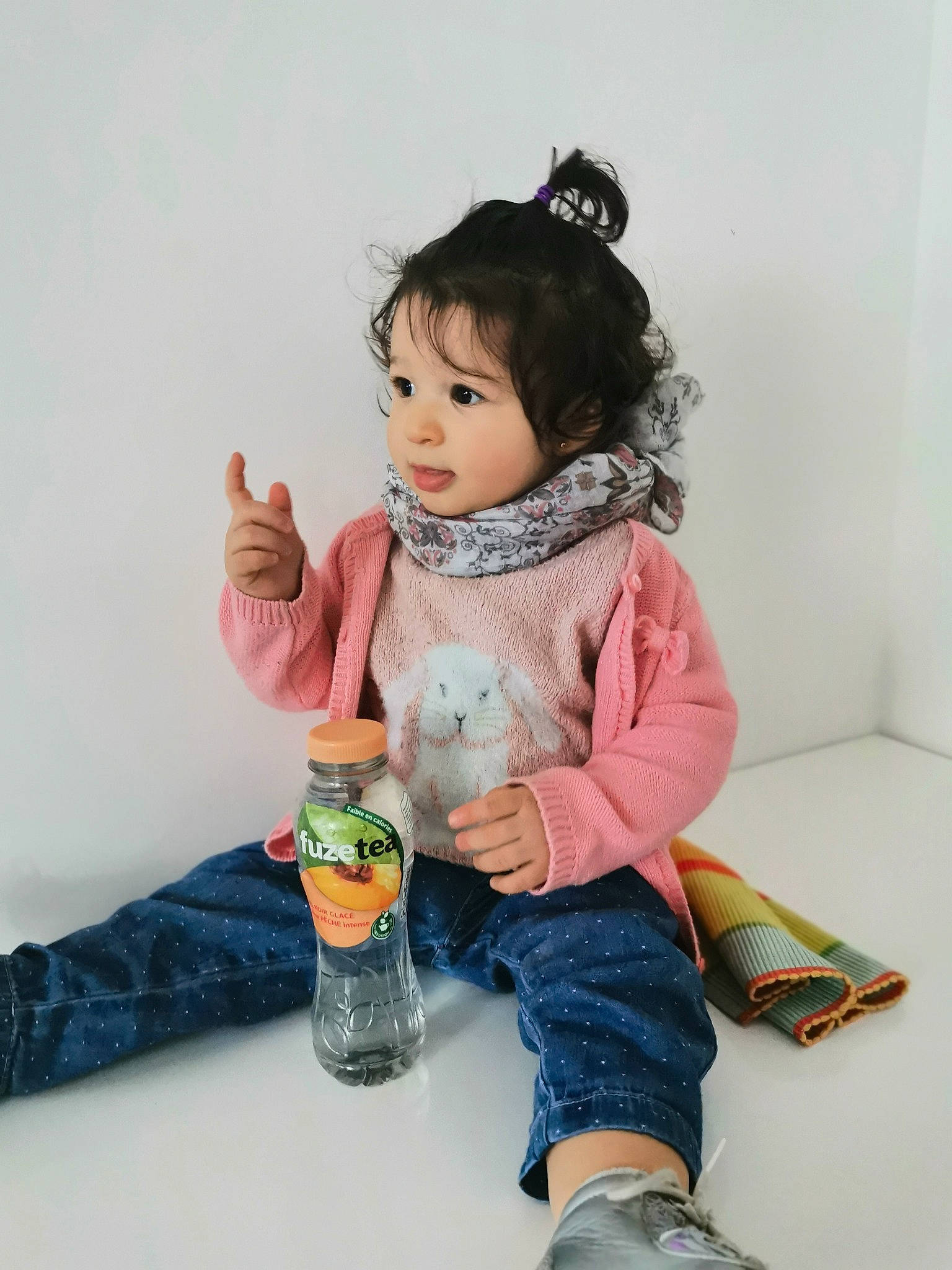 Juliette a rejoint le concours — aidez-le/la à gagner de superbes lots ! baby_toddler_clothing, cheek, child, denim, facial_expression, finger, flooring, gesture, happy, head, human_leg, jeans, joint, leg, person, sitting, skin, sleeve, t_shirt, thumb