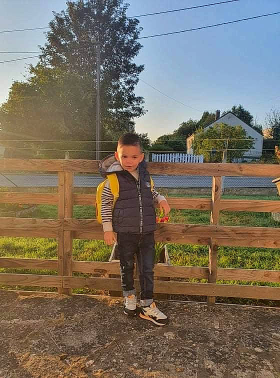 Kenzo participe au concours pour gagner de l'argent avec cette photo : boot, child, fence, footwear, grass, grassland, happy, home_fencing, jacket, landscape, leisure, people_in_nature, person, plant, recreation, sky, soil, toddler, tree, wood