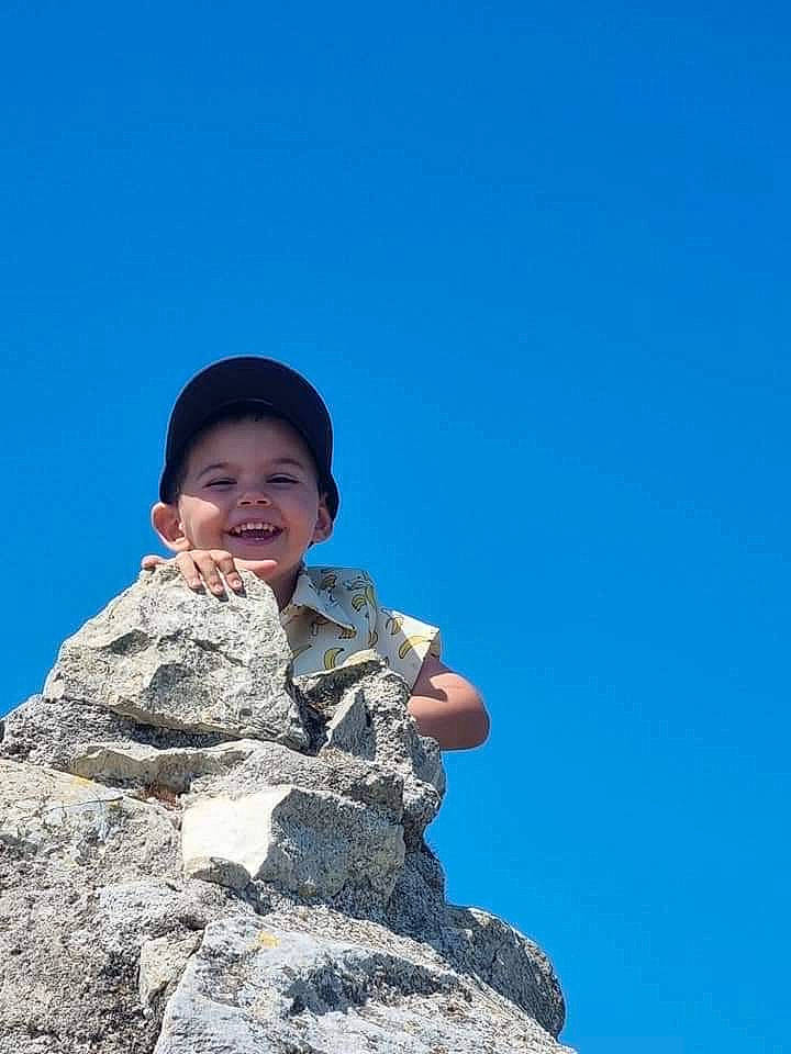 Kenzo participe au concours pour gagner de l'argent avec cette photo : bedrock, child, flash_photography, fun, gesture, happy, joy, landscape, leisure, outcrop, person, portrait_photography, recreation, rock, sand, sitting, sky, smile, soil, toddler