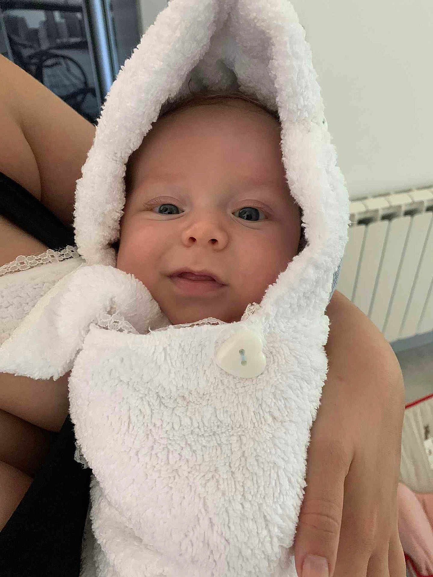 Liam a rejoint le concours — aidez-le/la à gagner de superbes lots ! baby, infant, face, eyes, smile, hood, towel, white, button, hand, arm, skin, person, indoor, portrait, cute, soft, warm, cozy, fabric
