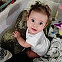 Daniela joined the competition — help win amazing prizes! baby, child, curly_hair, white_shirt, pillow, playpen, blankets, toy, indoor, cute, infant, looking_up, soft_toys, toddler, happy, expression, hand, face, cuddly, home