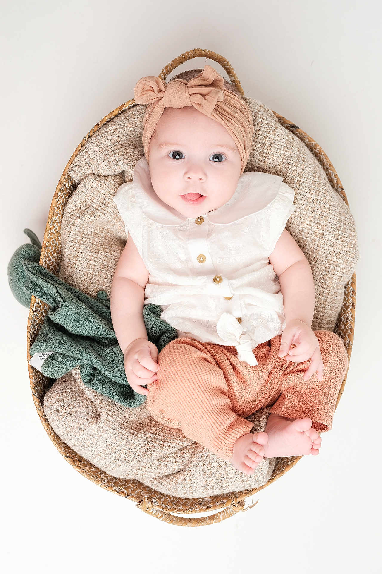 Enaé participe au concours pour gagner de l'argent avec cette photo : baby, infant, basket, blanket, headband, bow, clothing, white_background, plush_toy, cute, soft_texture, child, portrait, sitting, indoors, happy, small_feet, buttoned_shirt, cozy, closeup