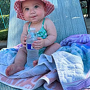 Jade joined the competition — help win amazing prizes! baby, child, sunhat, water_bottle, towel, lounge_chair, outdoor, summer, swimsuit, cute, sitting, skin, feet, hand, daylight, relaxation, expression, portrait, infant, vacation