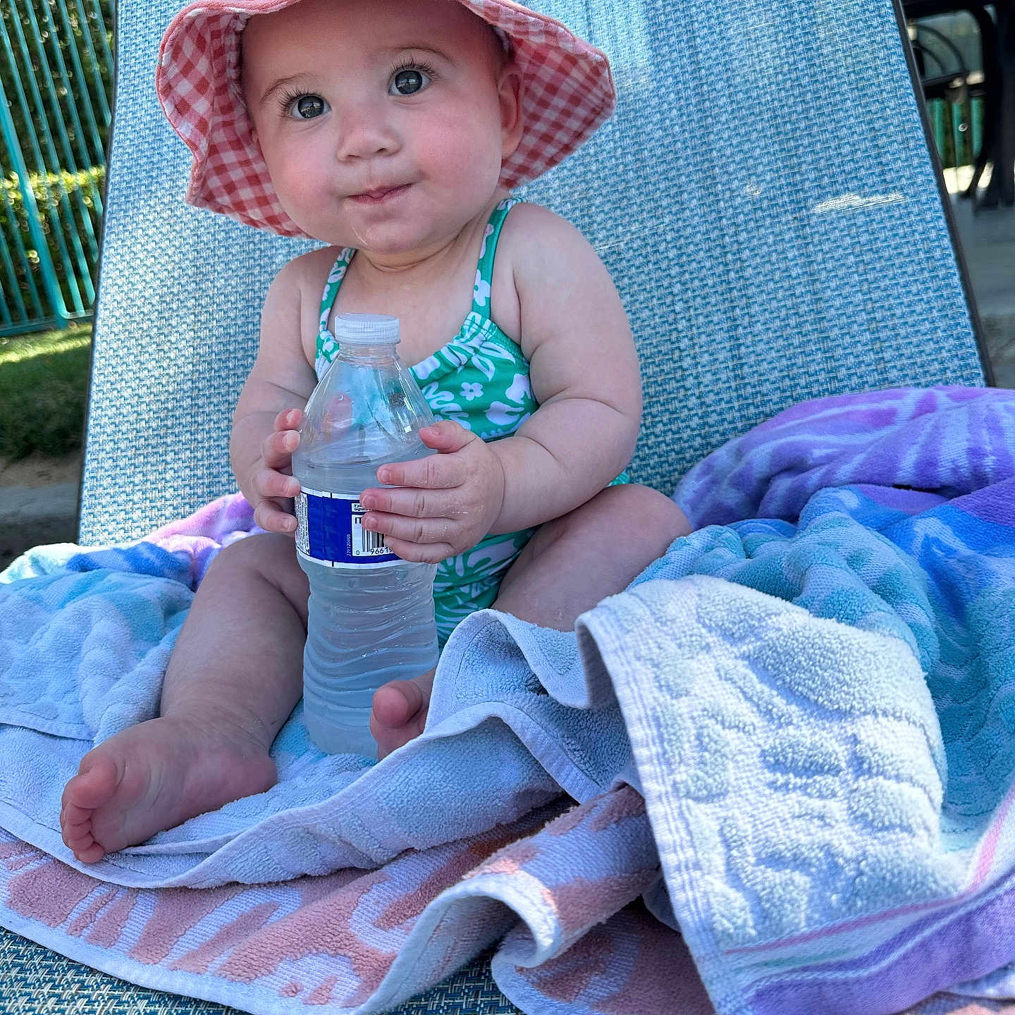 Jade joined the competition — help win amazing prizes! baby, child, sunhat, water_bottle, towel, lounge_chair, outdoor, summer, swimsuit, cute, sitting, skin, feet, hand, daylight, relaxation, expression, portrait, infant, vacation