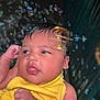 Lydia joined the competition — help win amazing prizes! baby, infant, yellow_clothing, face, hand, bubbles, skin, portrait, newborn, cute, child, expression, colorful, soft_lighting, indoors, closeup, person, young, adorable, peaceful