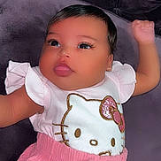 Lydia joined the competition — help win amazing prizes! adorable, arm_raised, baby, casual_wear, child, cute, eyes, face, hello_kitty, indoors, infant, lying_down, pink_clothing, plush_surface, portrait, purple_background, small_child, soft_texture, white_top, young
