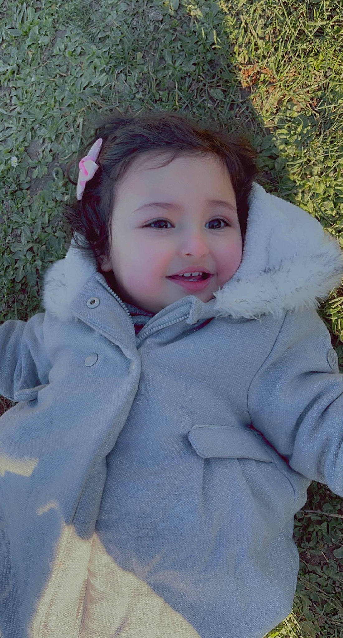 Mayssa participe au concours pour gagner de l'argent avec cette photo : cheek, eye, eyebrow, eyelash, face, grass, happy, iris, jacket, lip, nose, outerwear, people_in_nature, person, plant, skin, sleeve, smile, textile, toddler