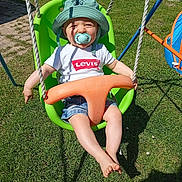 Lynao participe au concours pour gagner de l'argent avec cette photo : toddler, child, swing, green_swing, pacifier, hat, sunhat, shorts, white_tshirt, levi's, outdoor, grass, playground, summer, daylight, shadow, happy, smiling, barefoot, baby