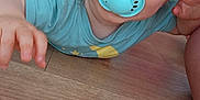 Lynao participe au concours pour gagner de l'argent avec cette photo : baby, blue_eyes, child, closeup, crawling, curly_hair, cute, floor, hand, head, indoor, infant, pacifier, person, playful, smiling, stroller, toy, tshirt, wooden_floor