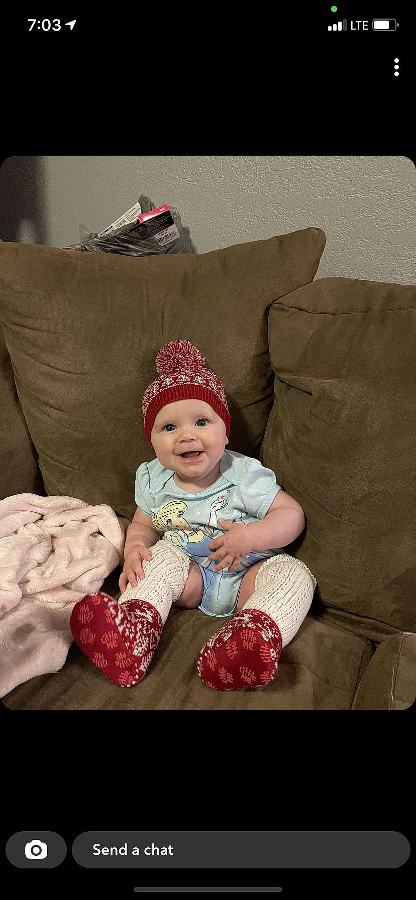 Lacey joined the competition — help win amazing prizes! baby, baby_toddler_clothing, cap, child, christmas, comfort, couch, eye, happy, head, headwear, lap, linens, living_room, magenta, person, pillow, sitting, sleeve, smile
