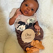 Jamier joined the competition — help win amazing prizes! baby, infant, one_month, mickey_mouse, clothing, blanket, soft, cute, portrait, child, milestone, wooden_sign, fur_booties, lying_down, indoors, young, face, hand, expression, cozy