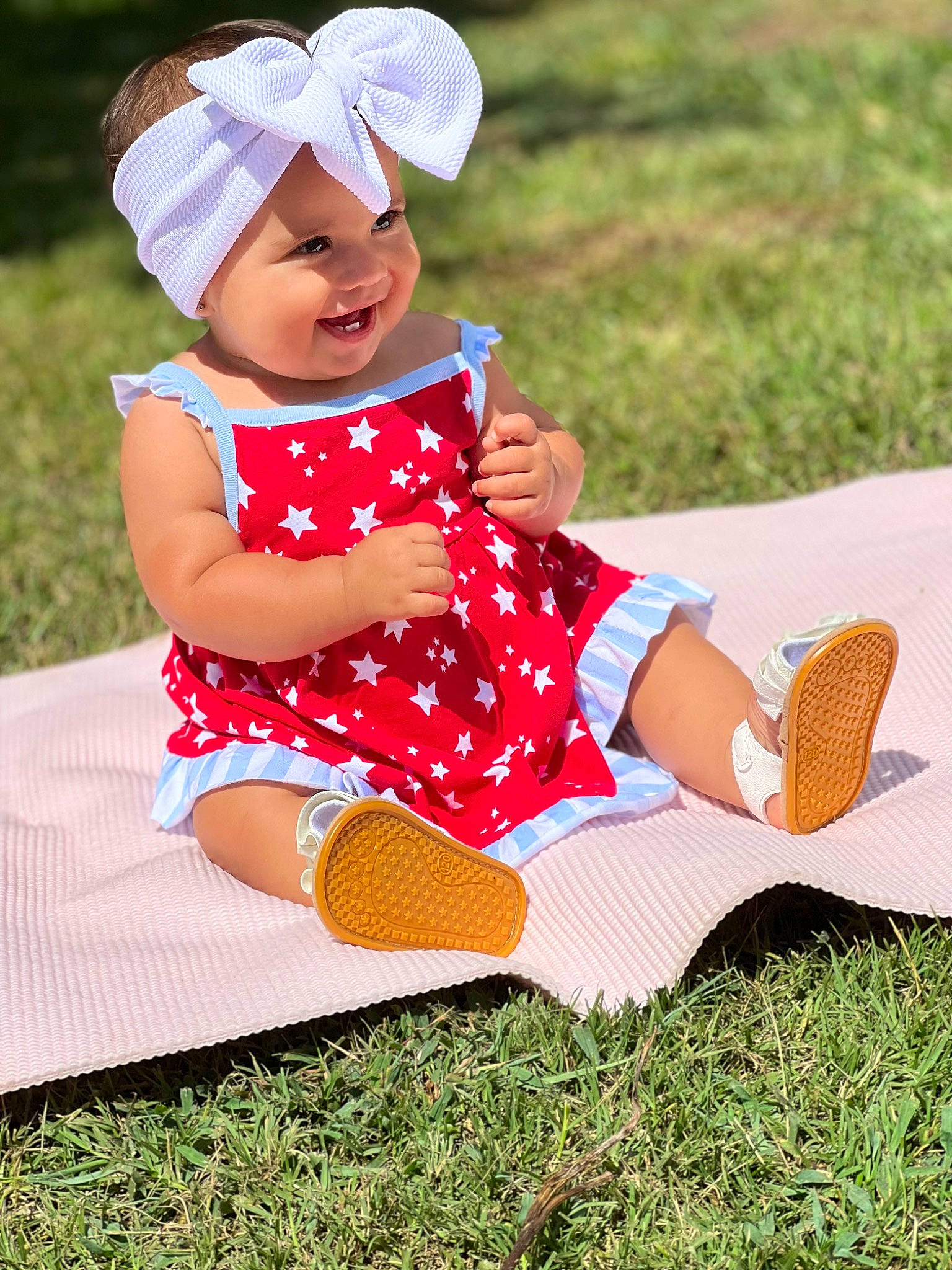 Emberly is registered to the contest to win money with this photo: baby, baby_toddler_clothing, cap, face, grass, happy, hat, headgear, headwear, joy, leaf, leg, leisure, people_in_nature, person, pink, recreation, shoe, sleeve, smile