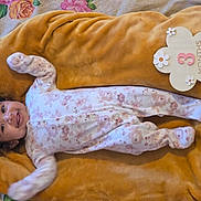 Gianna joined the competition — help win amazing prizes! baby, infant, smiling, floral_onesie, blanket, mustard_color, wooden_sign, 3_months, face, head, lying_down, happy, cute, child, soft_texture, indoors, portrait, baby_clothes, newborn, milestone