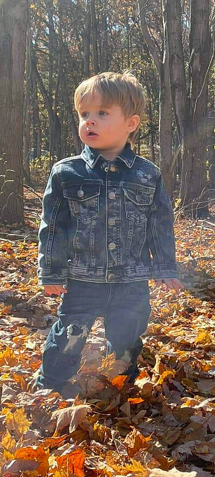 Malakai is registered to the contest to win money with this photo: baby_toddler_clothing, beauty, deciduous, denim, eye, face, forest, fur, grass, head, jacket, leaf, pattern, people_in_nature, person, sleeve, toddler, tree, trunk, wood