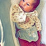 baby, infant, face, clothing, onesie, baby_seat, pattern, floral, red_pants, soft_toys, comfort, indoor, cute, newborn, portrait, child, relaxed, gazing, small_hands, head