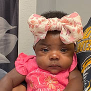 Kalenci joined the competition — help win amazing prizes! baby, infant, child, pink_clothing, headband, bow, person, indoor, holding, cute, portrait, hand, face, expression, sitting, toddler, apparel, pattern, wall, curtain