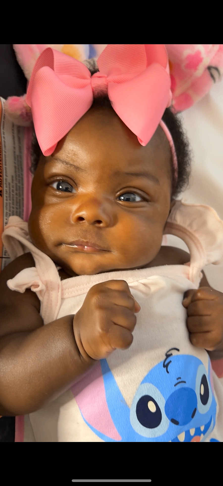 Kalenci is registered to the contest to win money with this photo: baby, infant, child, pink_bow, headband, fist, cute, close_up, cartoon_character, clothing, cute_expression, portrait, dark_skin, adorable, young_child, soft_lighting, baby_girl, cute_outfit, curious, indoor