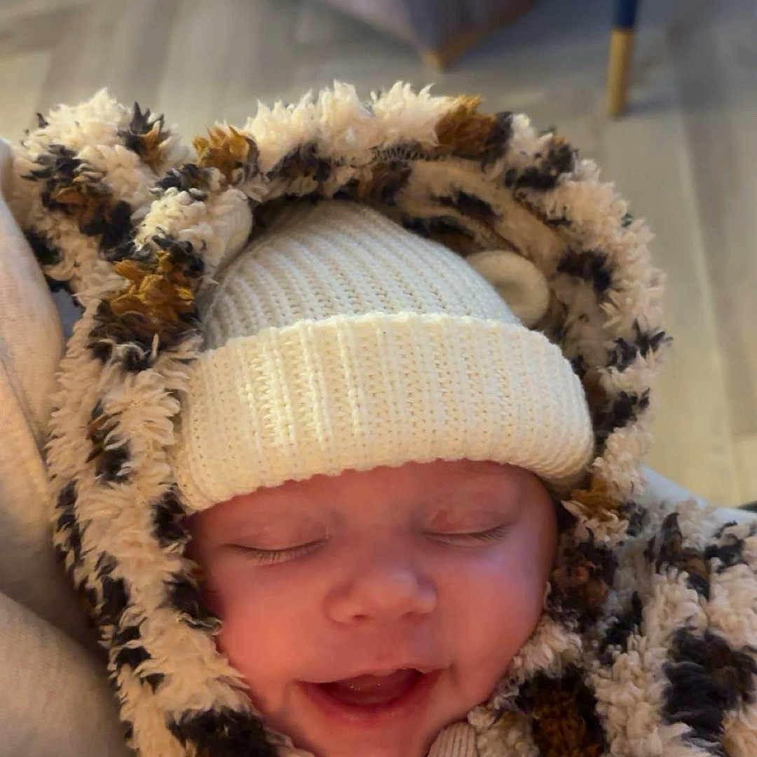 Saffie-Rae joined the competition — help win amazing prizes! apparel, baby, child, closed_eyes, cozy, cute, face, funny, fuzzy, happy, hoodie, indoor, infant, knit_hat, leopard_print, person, portrait, sleepy, smiling, warm_clothing