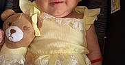 Cecilia joined the competition — help win amazing prizes! baby, bow, car_seat, child, dress, fabric, face, happy, headband, indoors, infant, photography, portrait, safety_buckle, seated, smiling, teddy_bear, toy, vehicle, yellow_dress