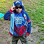 Callen is registered to the contest to win money with this photo: child, boy, hoodie, sunglasses, tie_dye_tshirt, graduate_tshirt, outdoor, grass, dirt, casual_clothing, pants, standing, confident, superhero, cape, hood, young, person, nature, playful