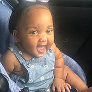 Anyla is registered to the contest to win money with this photo: baby, child, smiling, happy, car_seat, blue_outfit, bow, hair_accessory, infant, cute, portrait, sitting, indoor, clothing, person, face, skin, hand, foot, young_child