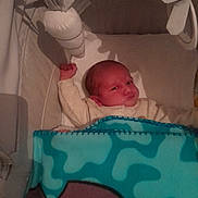 Maelan a rejoint le concours — aidez-le/la à gagner de superbes lots ! baby, infant, crib, blanket, toy, carrot, sleeping_area, face, expression, raised_arm, soft_toy, bed, child, indoors, cute, resting, pajamas, head, newborn, cozy