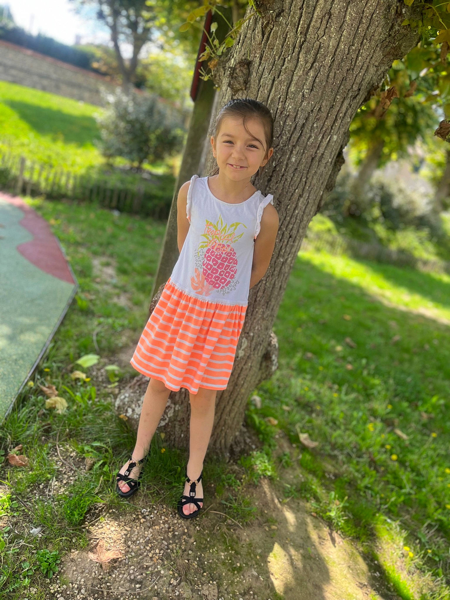 Salomé participe au concours pour gagner de l'argent avec cette photo : baby_toddler_clothing, child, day_dress, dress, fruit, fun, grass, grass_family, happy, joy, lawn, leisure, magenta, people_in_nature, person, plant, recreation, sandal, toddler, tree