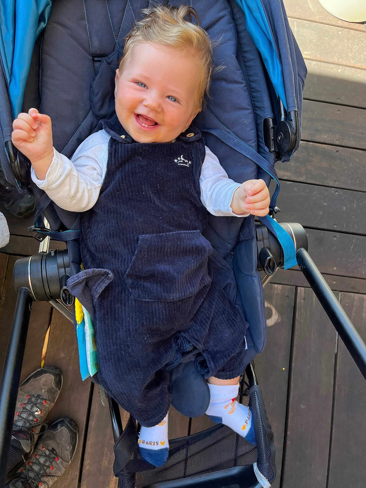Jules a rejoint le concours — aidez-le/la à gagner de superbes lots ! baby, smiling, stroller, blue_clothing, socks, happy, child, wooden_floor, footwear, infant, seat, person, cute, casual, indoor, portrait, baby_clothes, laughing, hands, hair