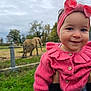 toddler, child, pink_sweater, headband, smile, outdoor, grass, elephant, animal, fence, tree, nature, person, baby, portrait, cute, holding, jeans, overcast_sky, daytime