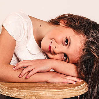 Noelie participe au concours pour gagner de l'argent avec cette photo : art_model, black_hair, brown_hair, close_up, comfort, elbow, eyelash, face, fashion_model, flash_photography, gesture, happy, human_leg, jewellery, layered_hair, lip, neck, sitting, skin, smile